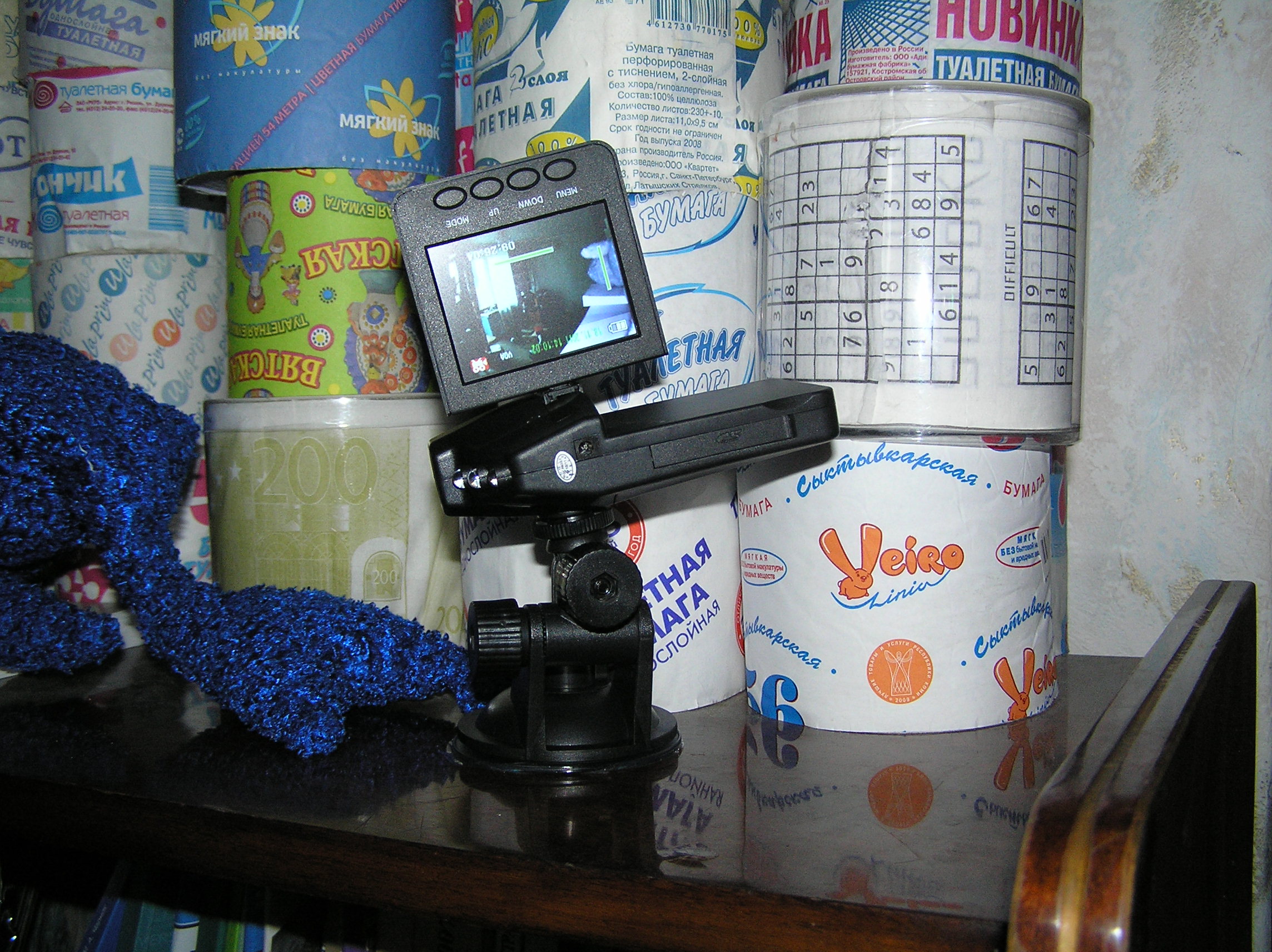 Автомобильный видеорегистратор в действии на фоне коллекции туалетной бумаги