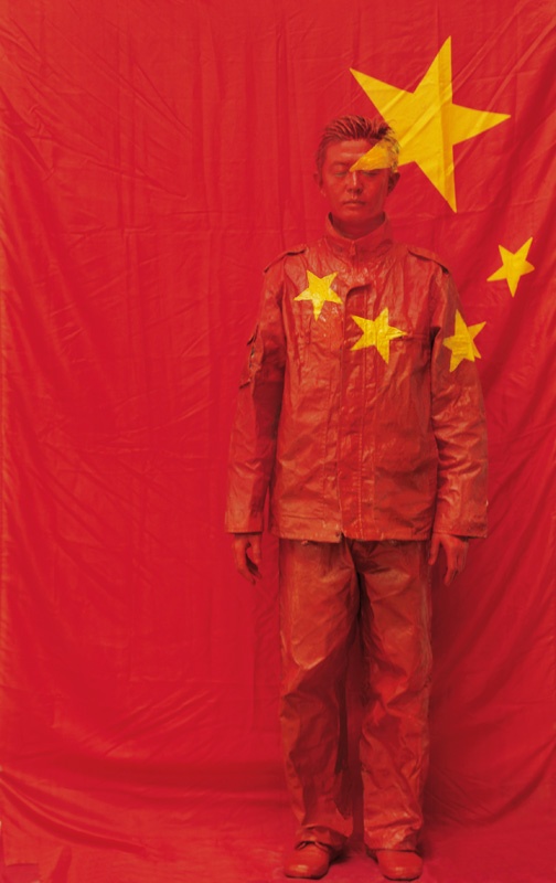 5. Лю Болинь Серия «Урбанистический камуфляж» — 26, 2006 На фоне китайского флага  © Courtesy of Liu Bolin/Galerie Paris-Beijing