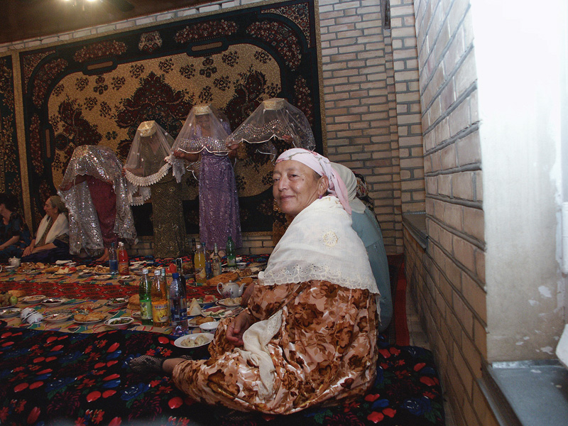 10. Бухара. Свадьба. Женщина на фоне кланяющейся невестки. 2005